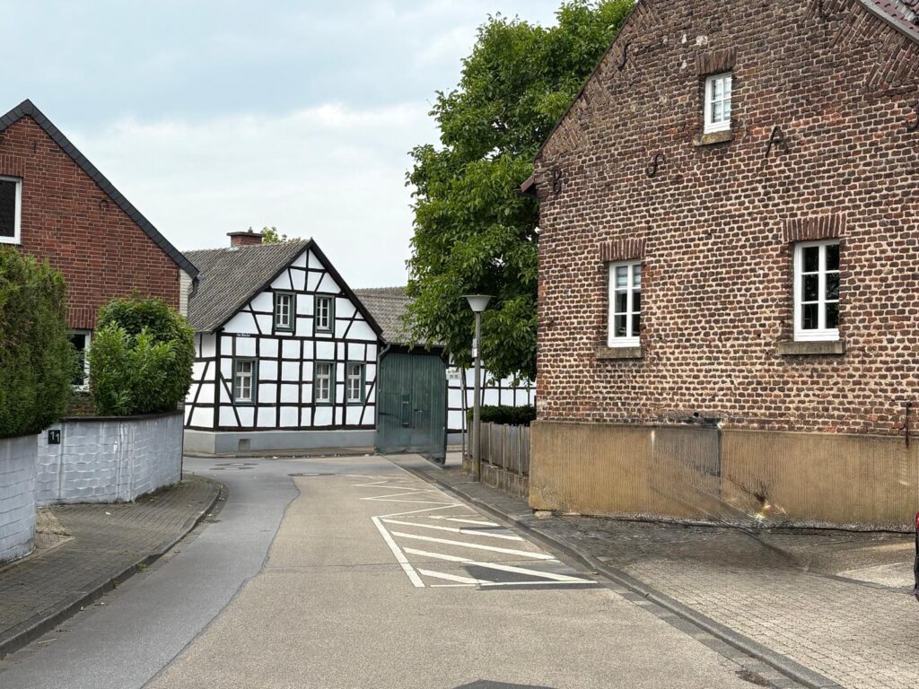 Gymnich: Alt und neu nebeneinander Eine alte Dorfstraße mit Fachwerk- und Backsteinhäusern, aber auch futuristische Neubaugebiete